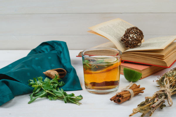 Herbal tea, cinnamon, and fresh herbs on a table — natural allergy remedies for seasonal relief.