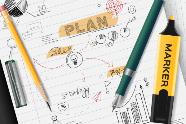 A notebook page showing the process of creating a student education plan with hand-drawn charts, a target, and the words "strategy" and "idea."